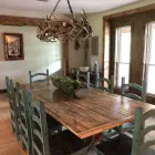 Renegade mule deer whitetail antler chandelier in natural finish hanging over a rustic wood dining table