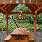 Cascade 3-Tier real antler chandelier installed in a timber-frame gazebo above a rustic picnic table