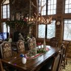 Big Sky Elk & Mule Deer Antler Chandelier lit above a rustic dining table decorated for the holidays