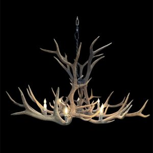 Yellowstone Elk Antler Chandelier illuminated on a black background, showing its full cascade of natural elk antlers