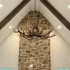 Yellowstone Elk Antler Chandelier in a bleached white finish, hanging from a vaulted white ceiling with dark wood beams
