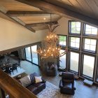 Selway 2-tier elk antler chandelier hanging in a vaulted great room with wood beams and large windows