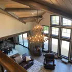 Selway 2-tier elk antler chandelier hanging in a vaulted great room with wood beams and large windows