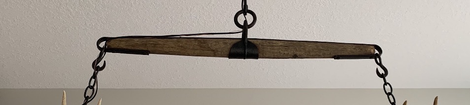 Close-up of the antique family yoke used as the hanging beam for a custom antler chandelier