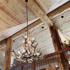 Salish Elk & Mule Deer Antler Chandelier lit in a vaulted timber-frame great room