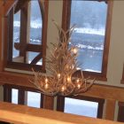 Salish Elk & Mule Deer Antler Chandelier illuminated above a great room with a river view