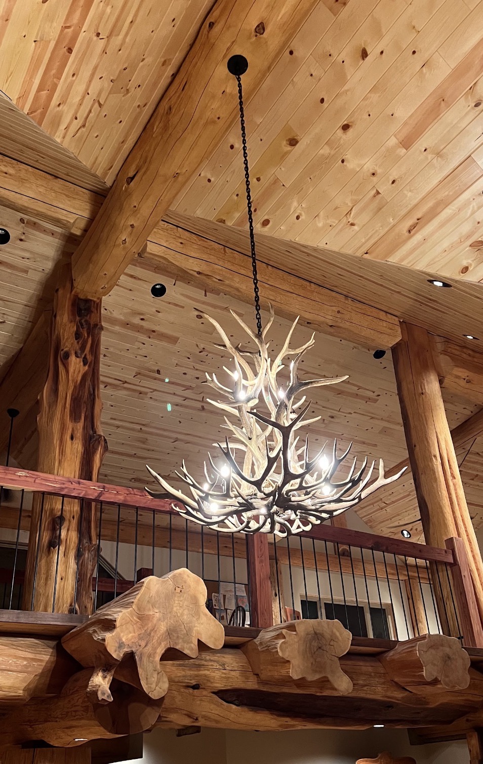 Salish Elk & Mule Deer Antler Chandelier lit above a vaulted great room loft