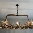 Roundup linear antler chandelier lit above a kitchen, close view of the real whitetail antler frame