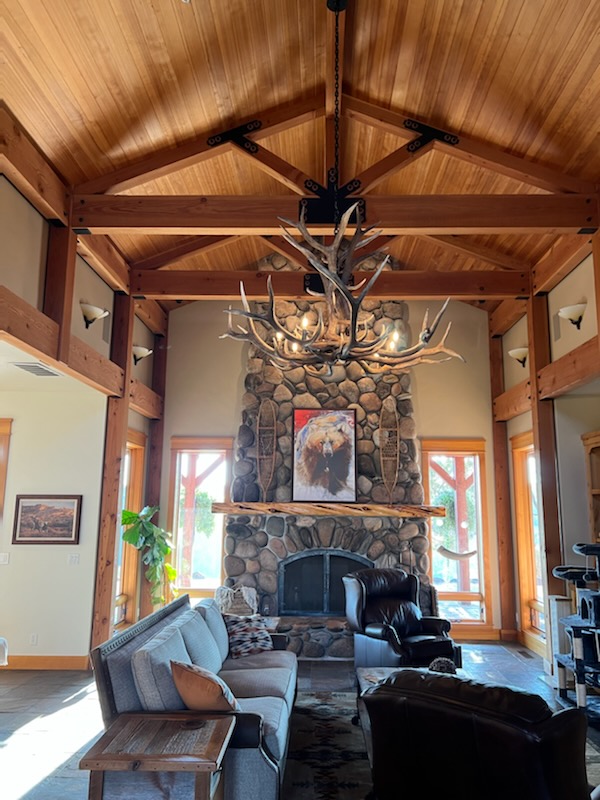 Yellowstone Elk Antler Chandelier in a Timber Great Room Yellowstone elk antler chandelier in a timber great room with a stone fireplace