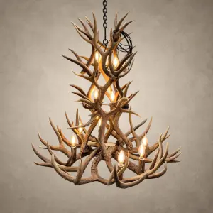 Cascade 3-tier mule deer antler chandelier lit with 12 candle-style bulbs, hanging from a black iron chain