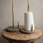 Two antler paper towel holders, one with a gray base and one with a brown wood base holding a roll