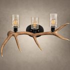 Ridgeline elk antler wall light with seeded glass cylinders glowing warm over filament bulbs