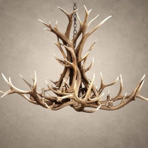 Snowcrest elk antler chandelier with a tall twisted center of Rocky Mountain elk antler and a wide sweeping ring of antler around 12 candle-style lights, hanging from an iron chain