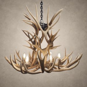 Deerlodge mule deer antler chandelier in natural antler finish with lit candle-style bulbs, hanging from a black iron chain