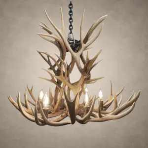 Deerlodge mule deer antler chandelier in natural antler finish with lit candle-style bulbs, hanging from a black iron chain