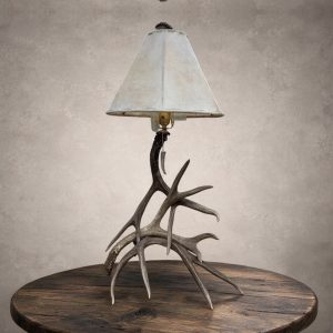 Mule deer antler table lamp – Madison: real mule deer antler base with a rawhide shade and antler-tip pull chain, on a wood side table