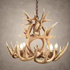 Two Tier Whitetail antler chandelier lit with candle-style bulbs, an upper tier of crossed whitetail antler above a lower ring of antler and lights, hanging from an iron chain