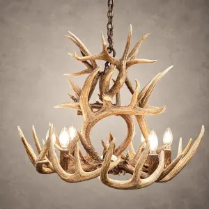Two Tier Whitetail antler chandelier lit with candle-style bulbs, an upper tier of crossed whitetail antler above a lower ring of antler and lights, hanging from an iron chain