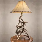 Whitetail antler table lamp – Silverbow: interlocking whitetail deer antler base with a laced rawhide shade and brass pull-chain socket, on a wood side table